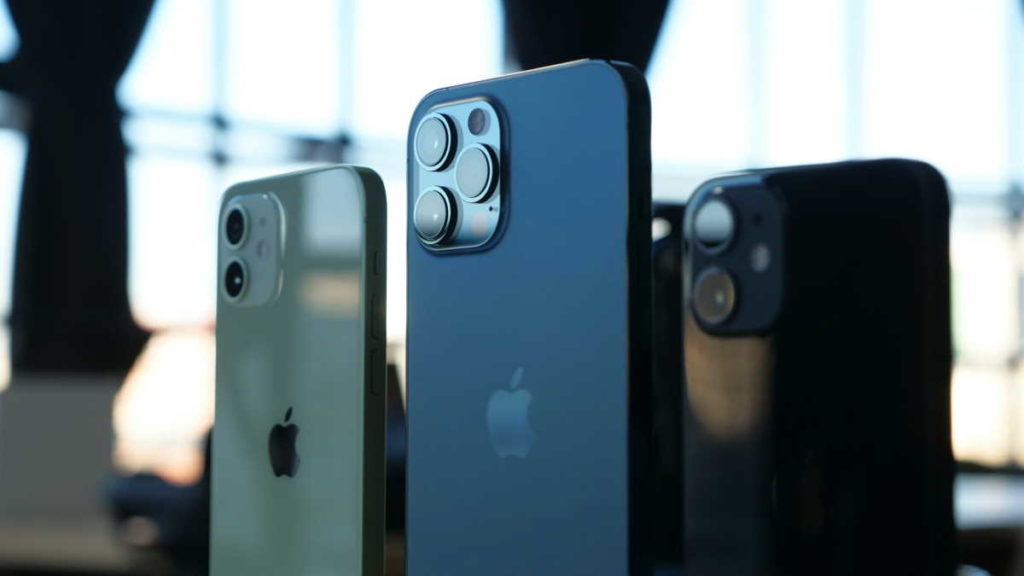 Três iPhones de cores diferentes mostrados de costas