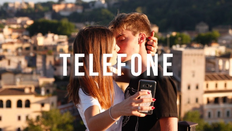 Dois jovens tirando uma selfie com telemóvel preto