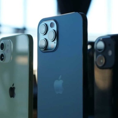 Três iPhones de cores diferentes mostrados de costas
