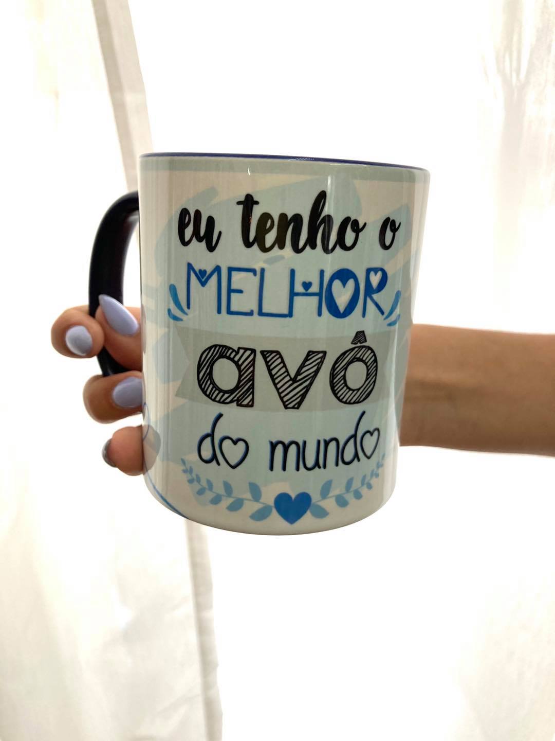 Caneca eu tenho o melhor avô Caneca branca com texto em português sobre avô, decorada com corações e ramos azuis.