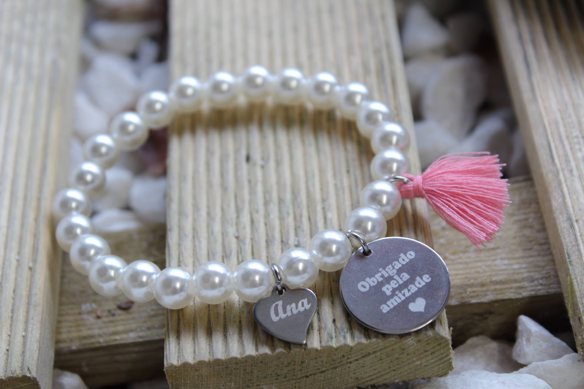 Pulseira obrigada pela amizade Pulseira perolada branca com pendentes prateados e tassel rosa sobre madeira