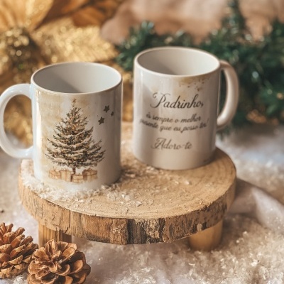 Duas canecas de cerâmica branca com tema de Natal em base de madeira com decoração festiva ao fundo