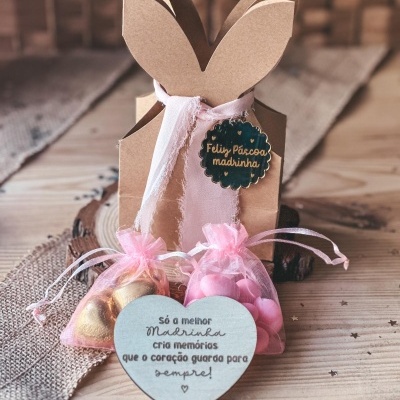 Embrulho de presente em forma de coelho e sacos transparentes com bombons, cartão coração com texto em português