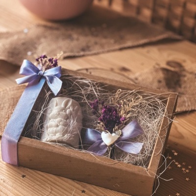 Caixa de presente com escultura branca de anjo e decoração de flores e fita azul