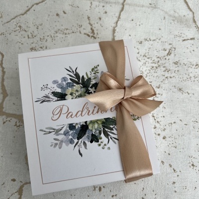 Caixa branca com decoração floral e laço bege com palavra Padrinhos