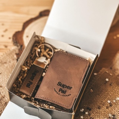 Carteira e porta-chaves de couro castanho numa caixa aberta