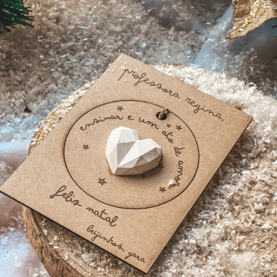 Cartão com pendente em coração branco e texto manuscrito sob neve artificial