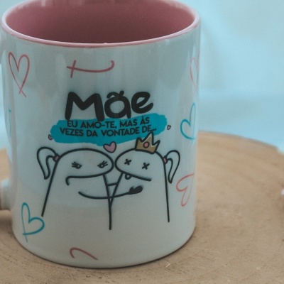 Caneca branca e rosa com desenho de animais e texto em português