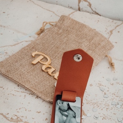 Capa de couro castanha com fotografia e saco de tecido rústico com decoração de madeira