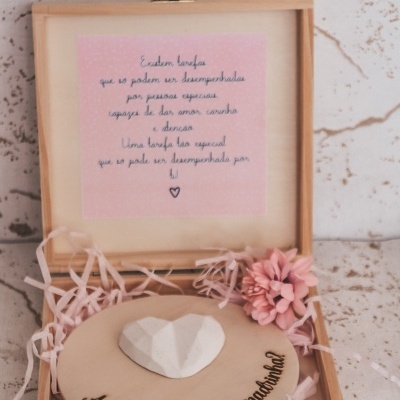 Caixa de madeira com placa gravada e flores cor-de-rosa