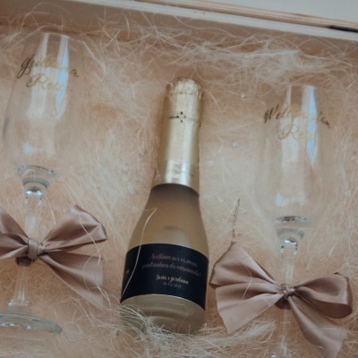 Conjunto de presente com champanhe e duas taças com laços numa caixa decorativa