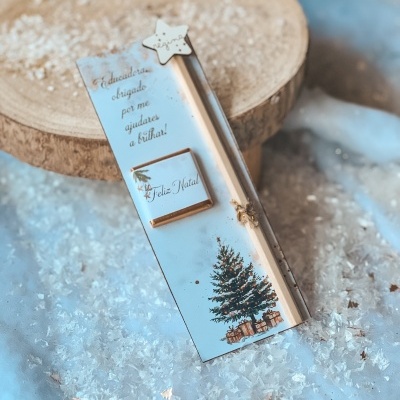 Marcador de livro com tema de Natal, árvore e presentes, borracha 'Feliz Natal' e estrela de madeira 'regina' em fundo com neve artificial