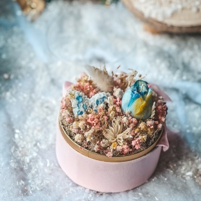 Caixa redonda rosa com decoração floral seca e vela azul