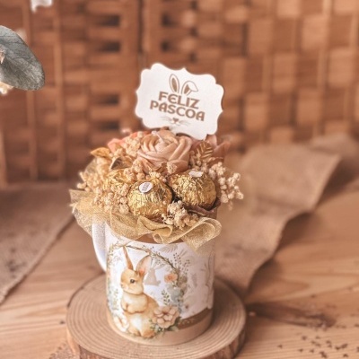Arranjo decorativo de Páscoa com coelho, flores secas e chocolates