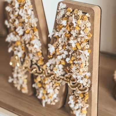 Letra decorativa M em madeira com flores secas e ornamento metálico