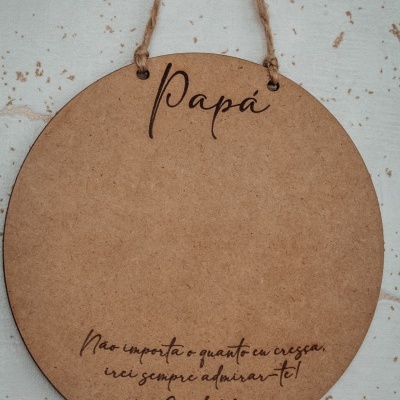 Placa redonda pendurada de madeira com texto gravado em português