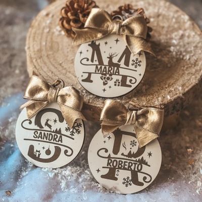 Ornamentos redondos com nomes personalizados e laços dourados em ambiente natalício