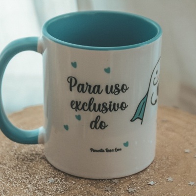 Caneca branca com interior e asa azul clara com texto em português