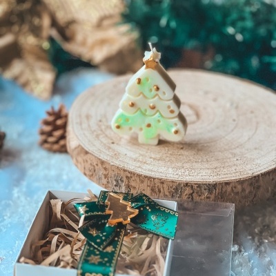 Vela em forma de árvore de Natal e caixa com fita verde e dourada
