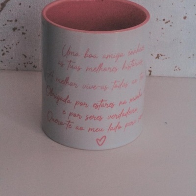 Caneca branca com interior rosa e texto em rosa apoiada numa superfície branca