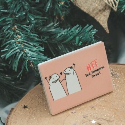 Pin metálico cor-de-rosa com desenho de dois personagens e texto BFF