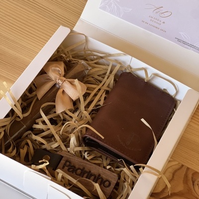 Caixa de presente com carteira de pele castanha, porta-chaves de madeira 'Padrinho' e convite em tom castanho claro