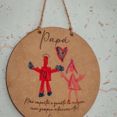 Placa redonda em madeira clara com desenho infantil e texto dedicado ao pai