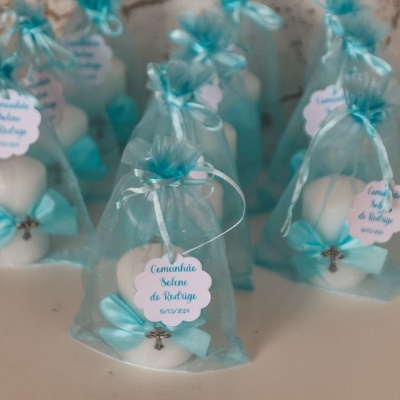 Doces decorativos em saco azul com etiqueta de comunhão e cruz metálica
