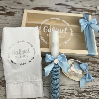 Conjunto de batismo com caixa, vela, toalha e concha decorados com laços azuis e bordado com nome Gabriel e data 09-08-2025