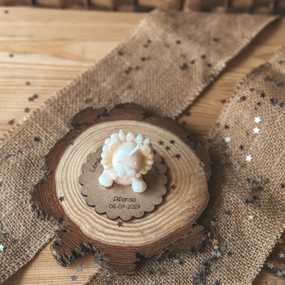 Vela em forma de leão sobre base de madeira e tecido de juta com estrelas prateadas