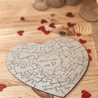 Puzzle de madeira em forma de coração com frases românticas e corações vermelhos ao redor