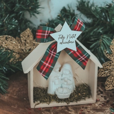 Presépio decorativo branco em estrutura de madeira com fita xadrez e estrela com texto de Natal