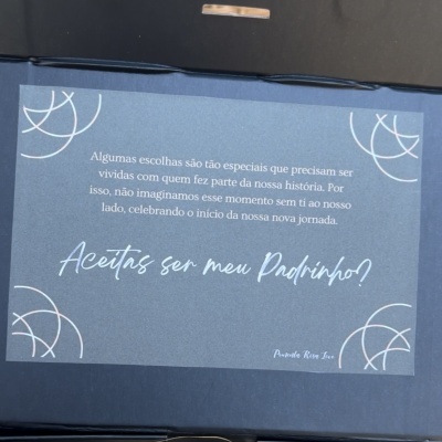 Mensagem em papel azul dentro de caixa preta a convidar para ser padrinho