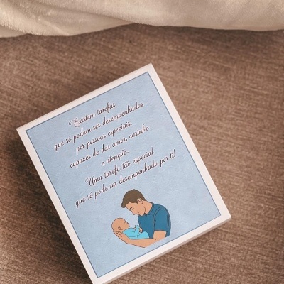 Caixa branca com ilustração de homem a segurar bebé e texto em português sobre fundo azul claro