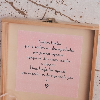 Caixa de madeira aberta com mensagem escrita em papel rosa dentro