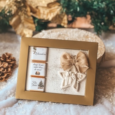 Pack de chocolates e decoração de Natal com moldura dourada.
