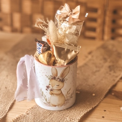 Caneca branca com desenho de coelho e chocolates inseridos