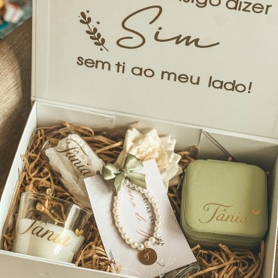 Caixa de presente branca com vela, pulseira, saco de tecido e caixa verde com nome Tânia
