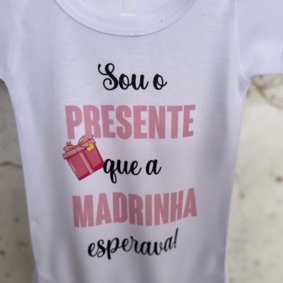Body de bebé branco com texto e desenho de presente rosa.