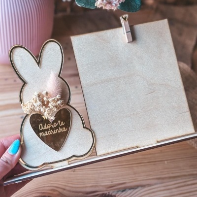 Placa decorativa de madeira com coelho e coração dourado com texto e flores secas