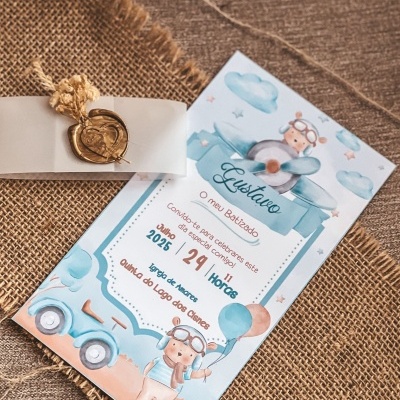 Convite de batizado com ilustrações azuis e castanhas sobre tecido rústico castanho