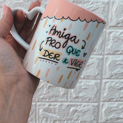 Caneca com pega em forma de coração e texto em português decorativa branca com rosa.