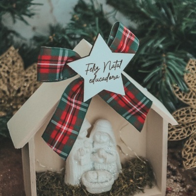 Presépio decorativo de Natal em madeira branca com laço xadrez e estrela com texto 'Feliz Natal educadora'.