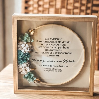Quadro de madeira com texto em português e flores artificiais decorativas.