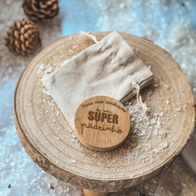 Caixa de madeira redonda com gravação para padrinho e saco de tecido em tronco de árvore.