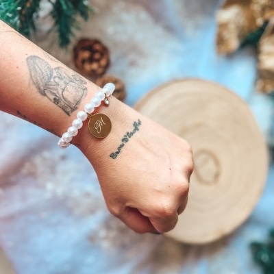 Pulseira de pérolas brancas com pendente dourado com letra M