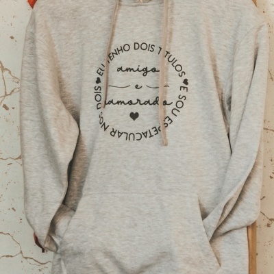 Sweatshirt cinzenta clara com capuz preto e texto em preto no peito