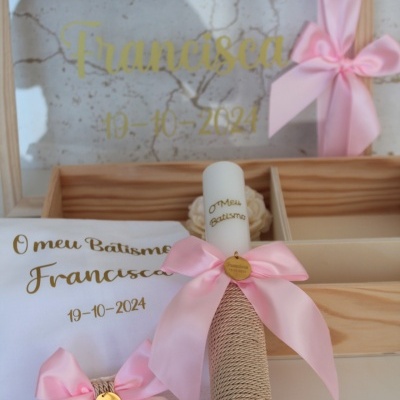 Conjunto de batismo com vela, toalha e moldura decorada com laços cor-de-rosa, texto dourado e madeira