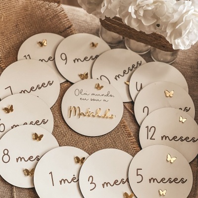 Placas redondas brancas para marcação de meses de bebé com borboletas douradas e texto Olá mundo, eu sou a Matilde