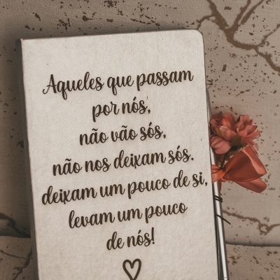 Caderno com citação em português e marcador com flor coral